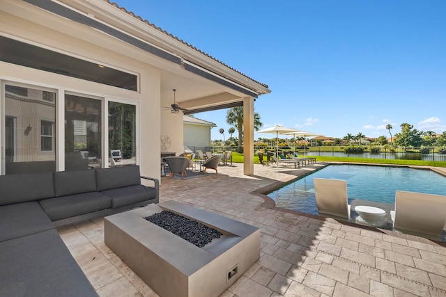 view of patio / terrace with ceiling fan, a fenced in pool, an outdoor living space with a fire pit, and a water view