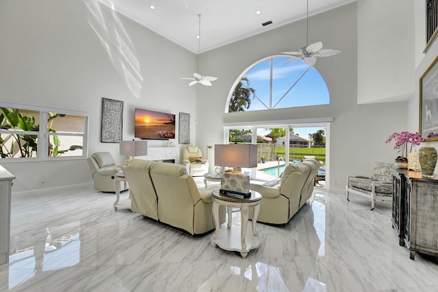 living room featuring a high ceiling, plenty of natural light, and crown molding