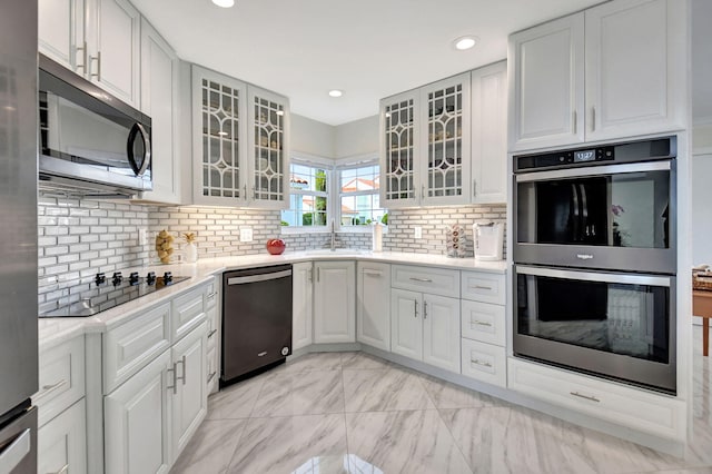 kitchen with decorative backsplash, white cabinets, appliances with stainless steel finishes, and sink