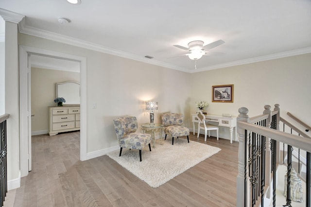 bedroom with ceiling fan, a nursery area, light wood-type flooring, and crown molding