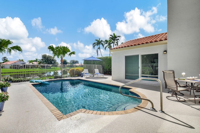 view of pool featuring a water view and a patio