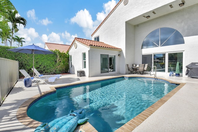 view of swimming pool featuring area for grilling and a patio area