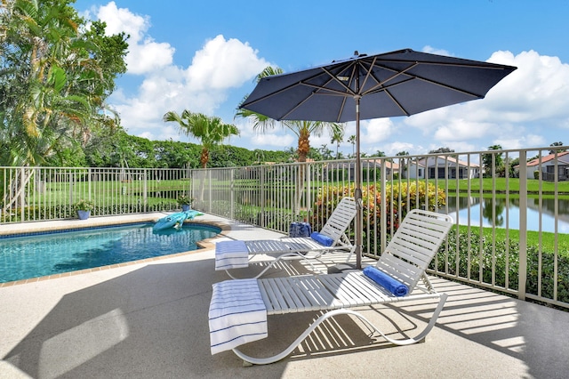 view of pool with a water view and a patio area