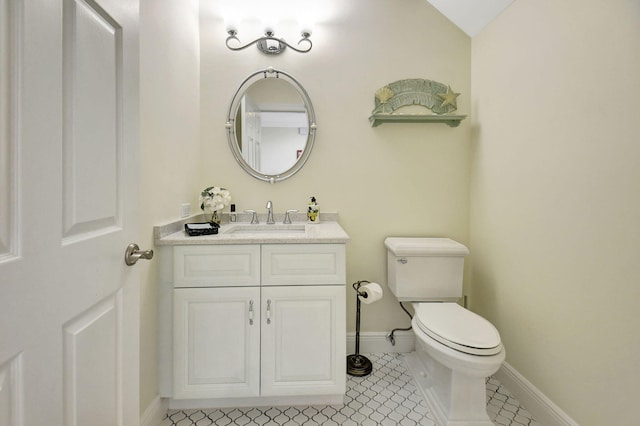 bathroom with lofted ceiling, tile patterned flooring, vanity, and toilet