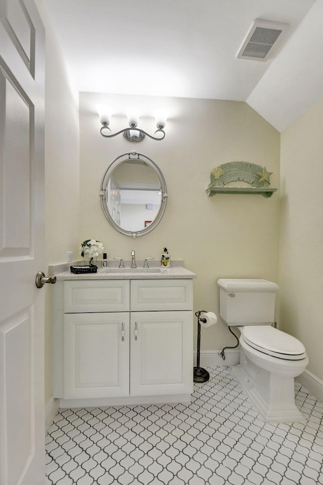 bathroom featuring lofted ceiling, tile patterned floors, vanity, and toilet