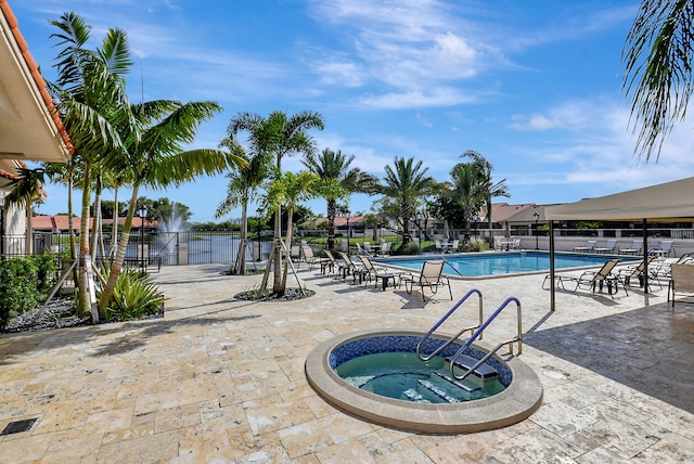 view of swimming pool featuring a community hot tub and a patio area