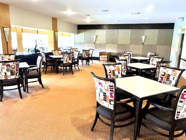 dining space with tile walls and light colored carpet