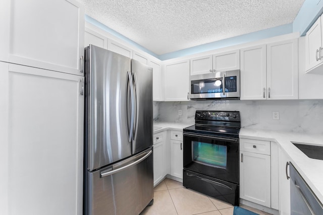 kitchen featuring white cabinetry, a textured ceiling, appliances with stainless steel finishes, and light tile patterned floors