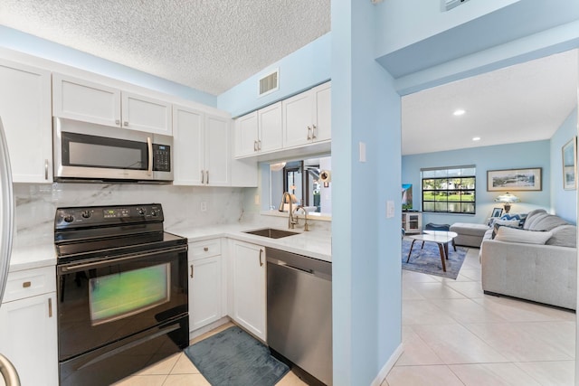 kitchen with white cabinets, sink, tasteful backsplash, a textured ceiling, and stainless steel appliances