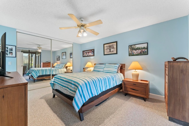 carpeted bedroom featuring a closet, ceiling fan, and a textured ceiling