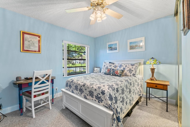 carpeted bedroom with a textured ceiling and ceiling fan