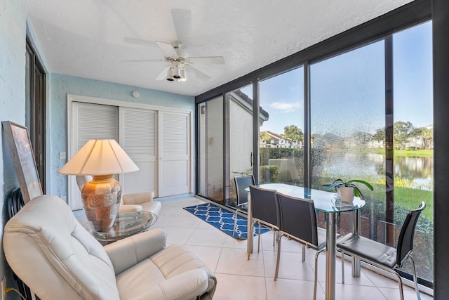 sunroom with a water view and ceiling fan