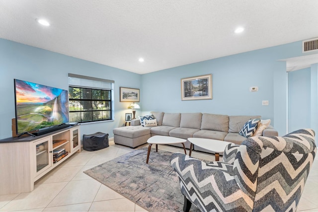 living room featuring a textured ceiling and light tile patterned floors