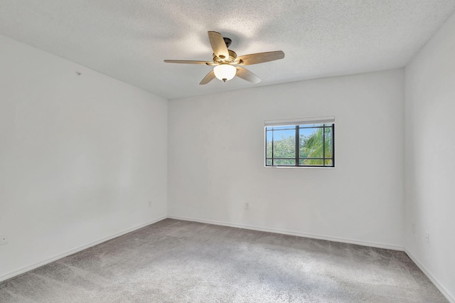 empty room with ceiling fan, a textured ceiling, and carpet