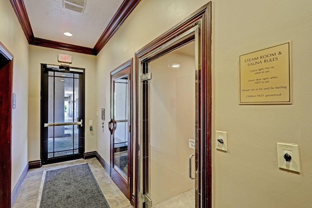 entryway with a textured ceiling and ornamental molding