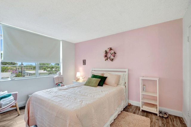 bedroom featuring wood-type flooring and a textured ceiling