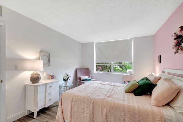 bedroom featuring a textured ceiling and hardwood / wood-style flooring