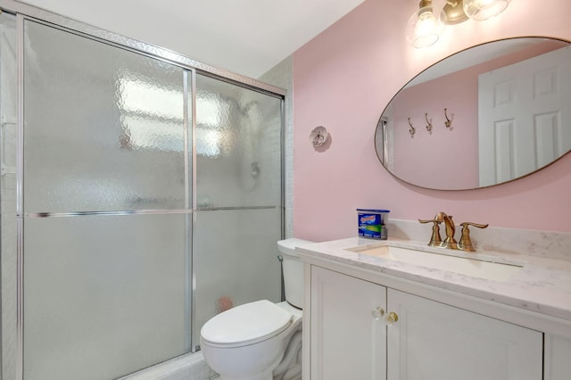 bathroom featuring an enclosed shower, vanity, and toilet