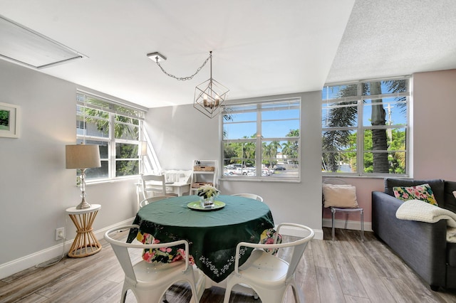 dining space with wood-type flooring and an inviting chandelier