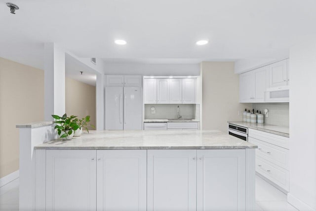 kitchen featuring tasteful backsplash, sink, white appliances, and white cabinetry