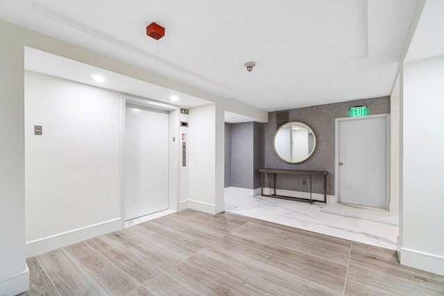 interior space featuring light wood-type flooring and elevator