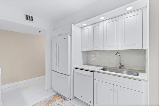 kitchen featuring tasteful backsplash, sink, white cabinets, white appliances, and light tile patterned floors