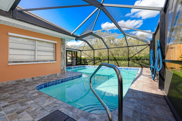 view of swimming pool with glass enclosure and a patio