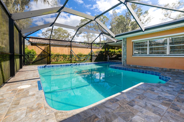 view of swimming pool with glass enclosure and a patio area