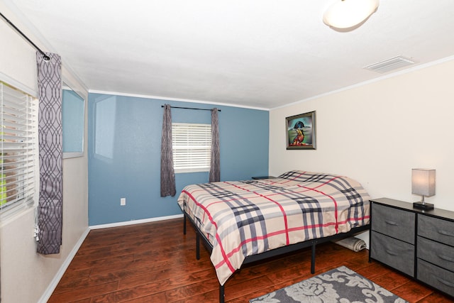 bedroom with ornamental molding and dark hardwood / wood-style flooring