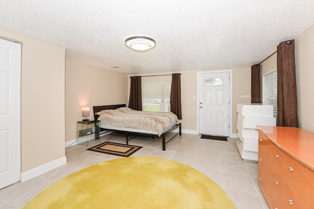 tiled bedroom featuring a textured ceiling