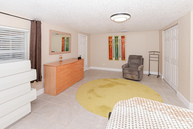 living area featuring a textured ceiling and light tile patterned floors