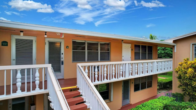 entrance to property with a porch and stucco siding