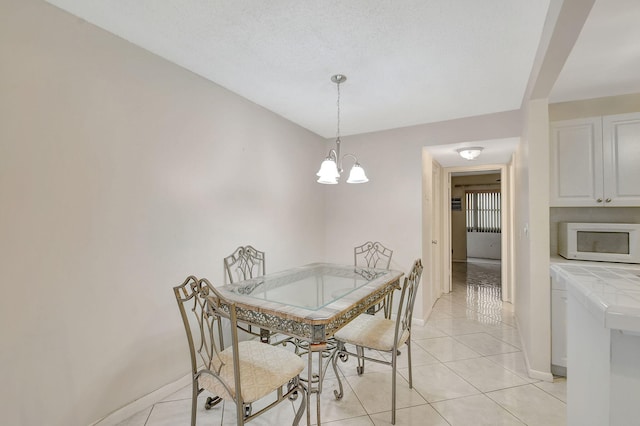 dining area with a chandelier, a textured ceiling, and light tile patterned floors