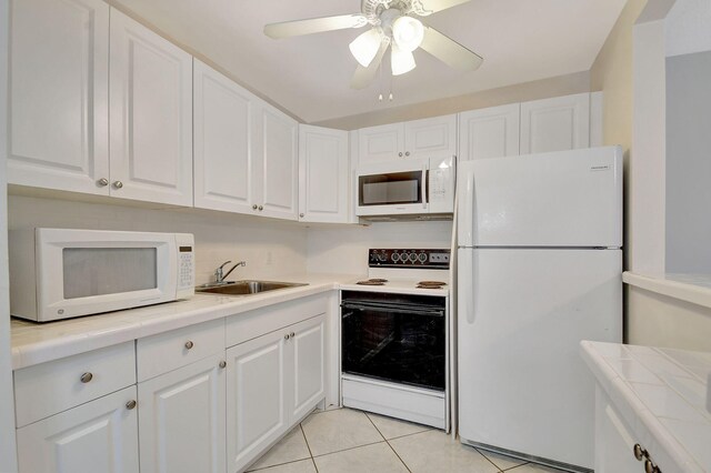 kitchen featuring white appliances, white cabinetry, and ceiling fan