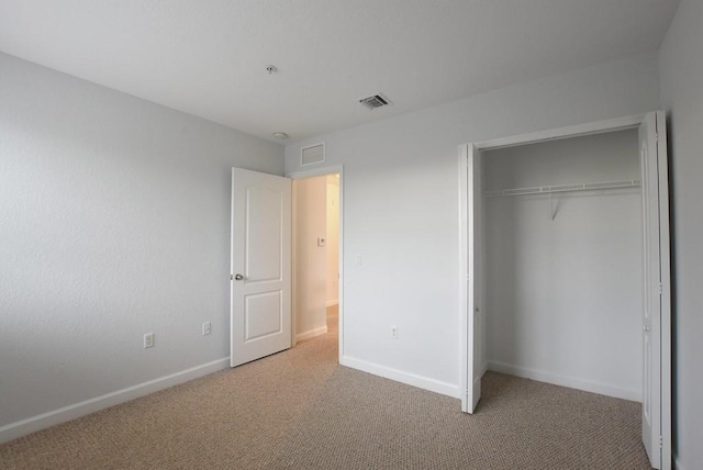 unfurnished bedroom with a closet and carpet flooring