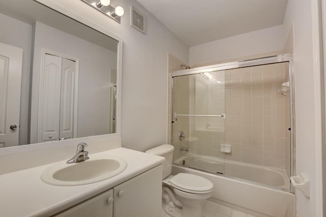 full bathroom with bath / shower combo with glass door, toilet, vanity, and tile patterned floors