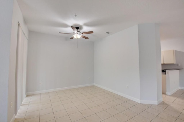 tiled spare room featuring ceiling fan