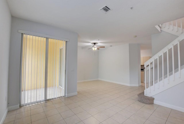 tiled spare room featuring ceiling fan