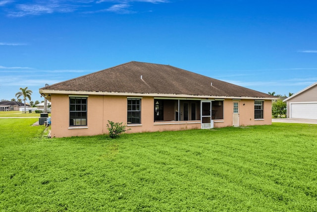 rear view of house featuring a yard and a garage