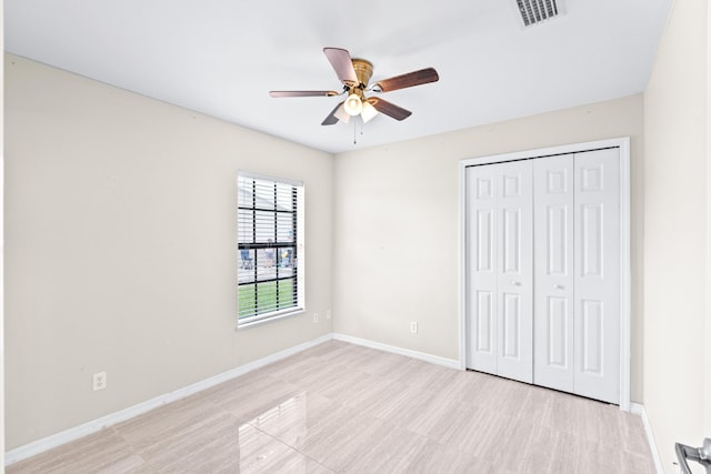 unfurnished bedroom featuring light hardwood / wood-style flooring, a closet, and ceiling fan