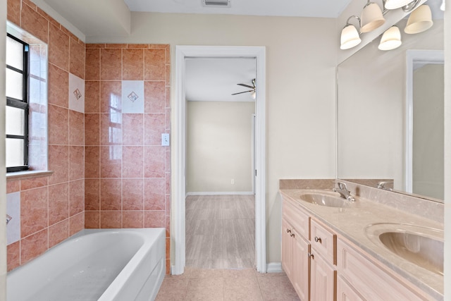 bathroom with vanity, a bath, a healthy amount of sunlight, and tile patterned flooring