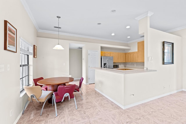 kitchen featuring light brown cabinets, kitchen peninsula, decorative backsplash, pendant lighting, and stainless steel appliances