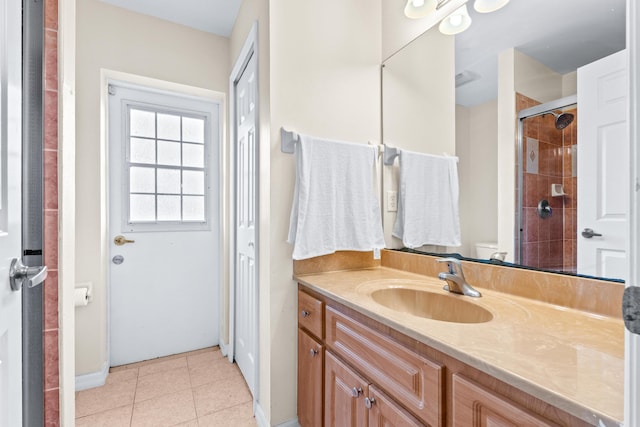 bathroom with vanity, a shower with shower door, toilet, and tile patterned floors