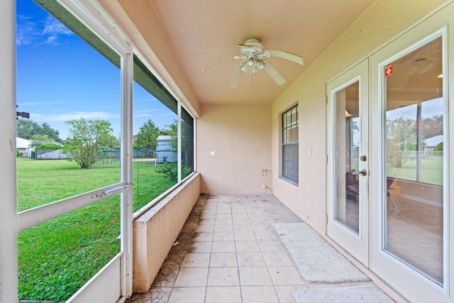 unfurnished sunroom with ceiling fan