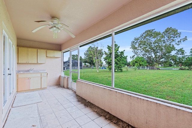 unfurnished sunroom featuring sink and ceiling fan