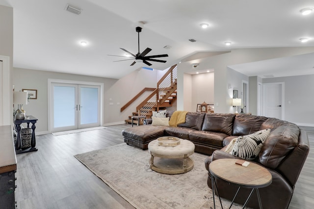 living room with ceiling fan, vaulted ceiling, french doors, and light hardwood / wood-style flooring