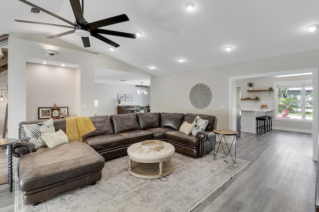 living room featuring lofted ceiling, wood-type flooring, and ceiling fan