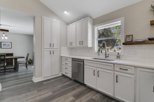 kitchen featuring lofted ceiling, sink, white cabinetry, stainless steel dishwasher, and decorative backsplash