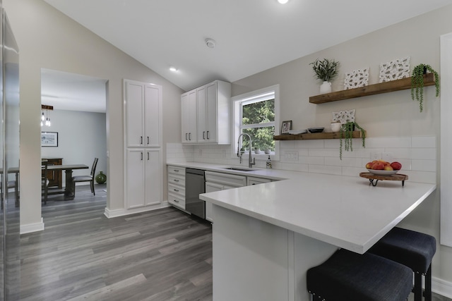 kitchen featuring sink, dishwasher, kitchen peninsula, and white cabinets