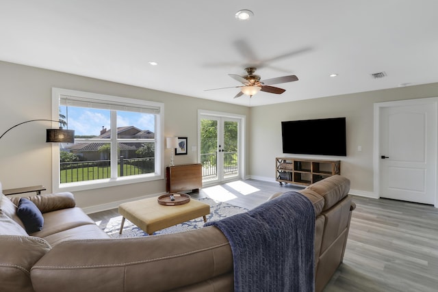 living room with french doors, ceiling fan, and light hardwood / wood-style floors